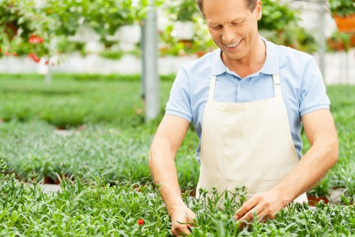 Worker wearing PPE using a hedge trimmer
